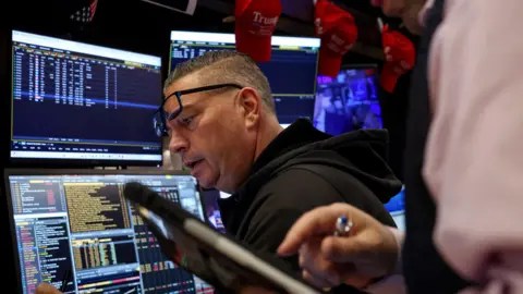 Reuters Traders work on the floor at the New York Stock Exchange (NYSE) in New York City, U.S., November 20, 2025.