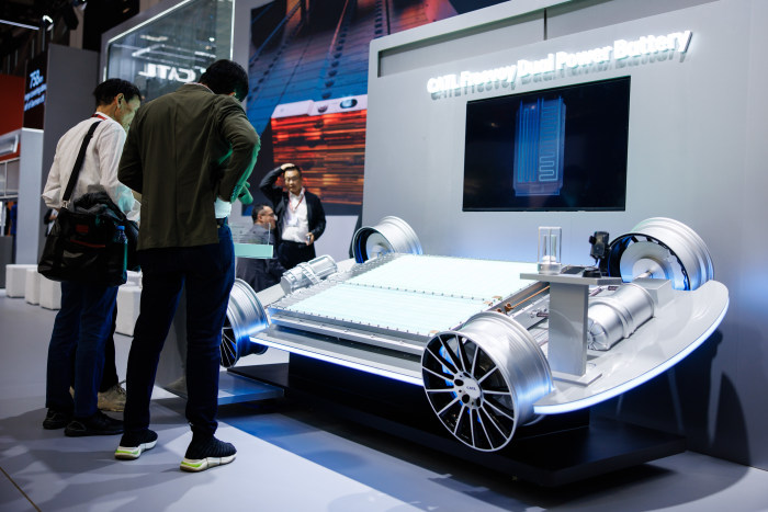 Visitors viewing a car model with batteries at the CATL booth at the IAA Mobility 2025 in Munich.
